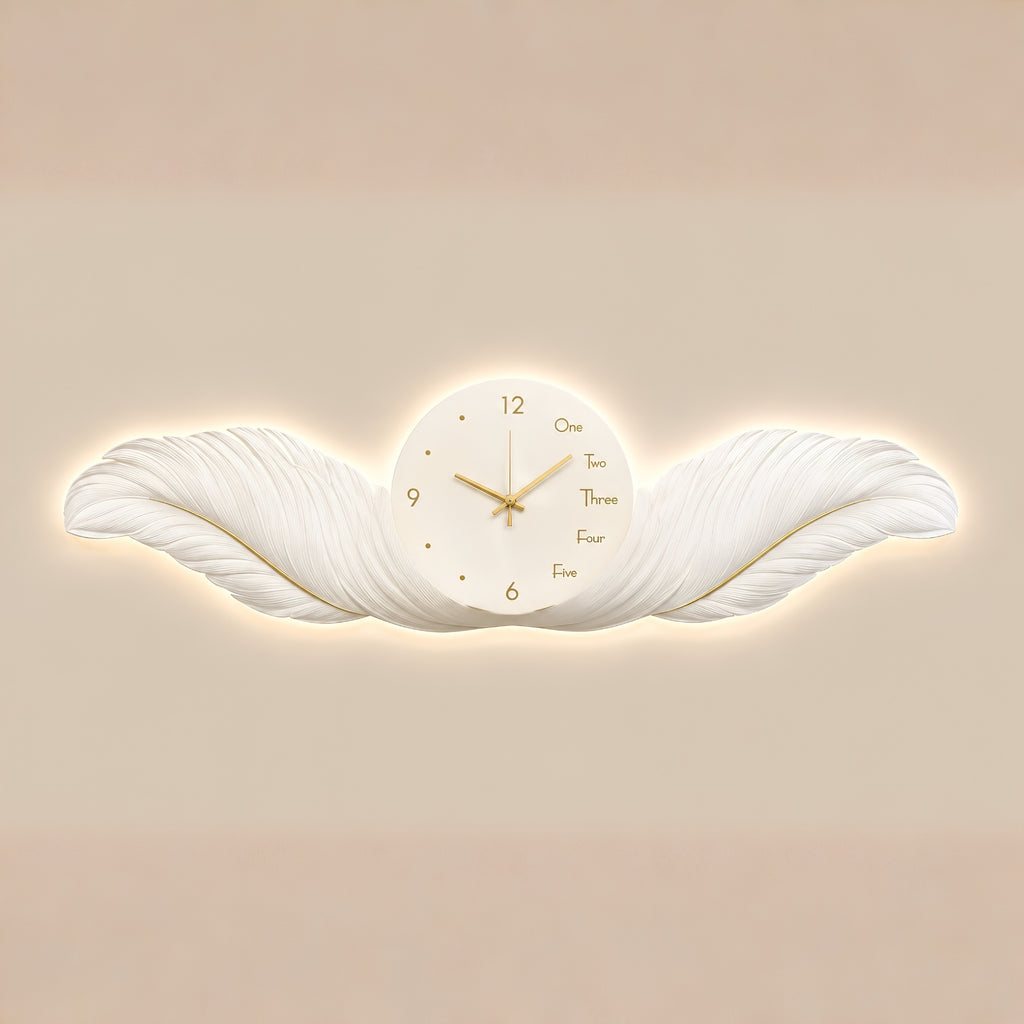A decorative wall clock shaped like a white wing, with a round white face, gold hands, and gold numerals, shown against a warm beige background.