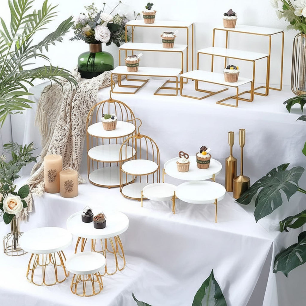 Decorative setup with gold and white tables, plants, and candles on a white background