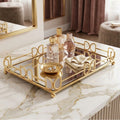 Gold-framed rectangular tray with mirrored glass panels, styled on a white marble surface with perfume bottles, a small gold dish, and folded cream fabric.