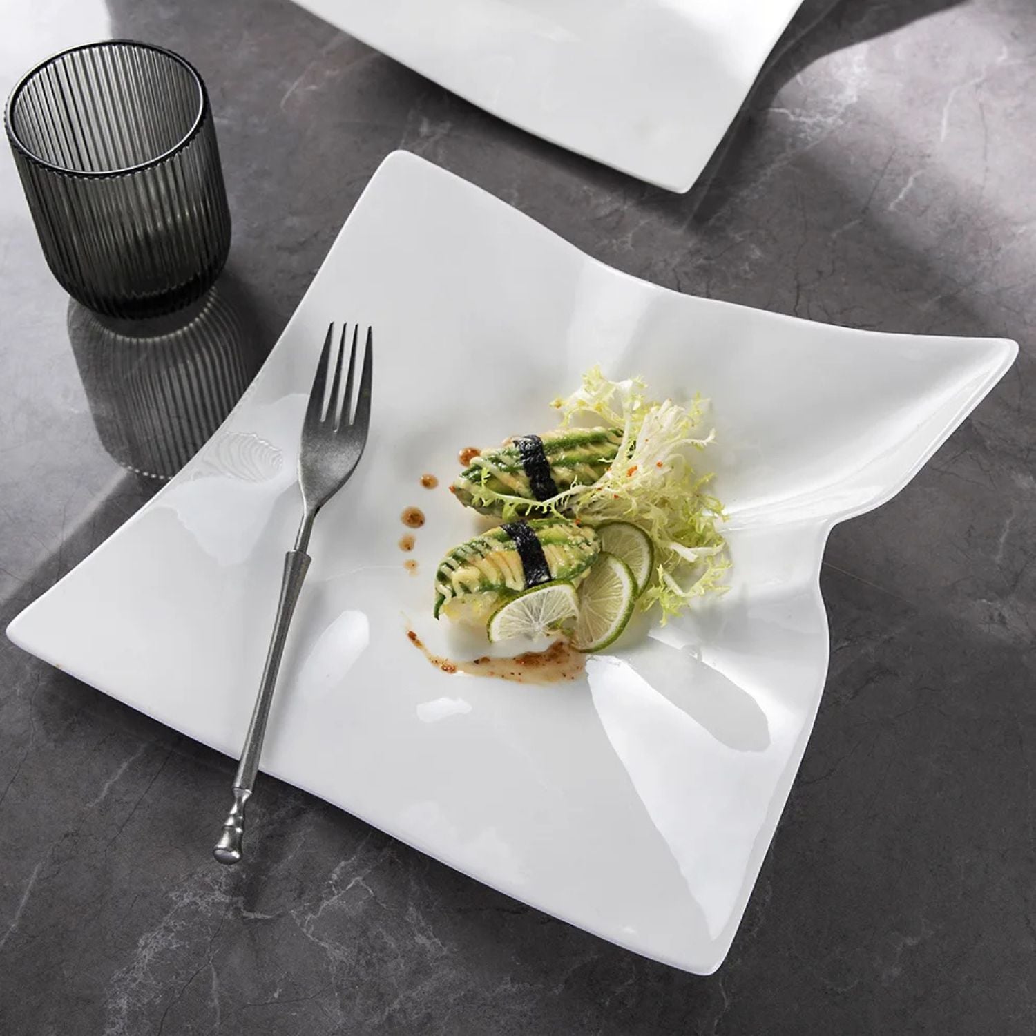 White plate with a dish of food and a fork on a dark surface