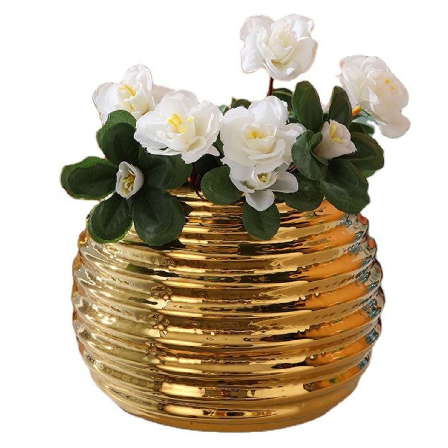 A shiny gold ribbed ceramic pot or planter holding white artificial roses with green leaves, isolated on a white background.