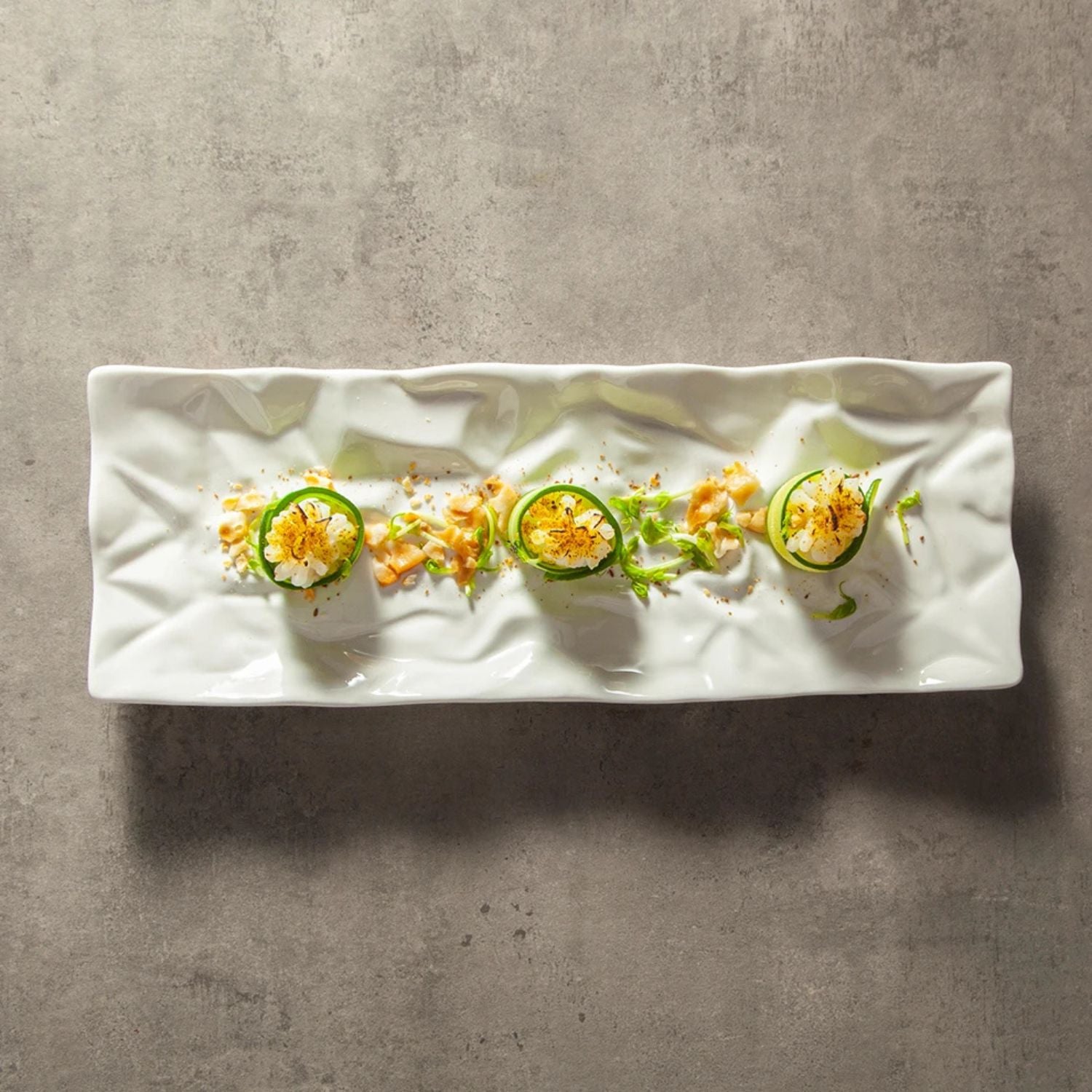 Plated dish with sliced vegetables on a textured surface