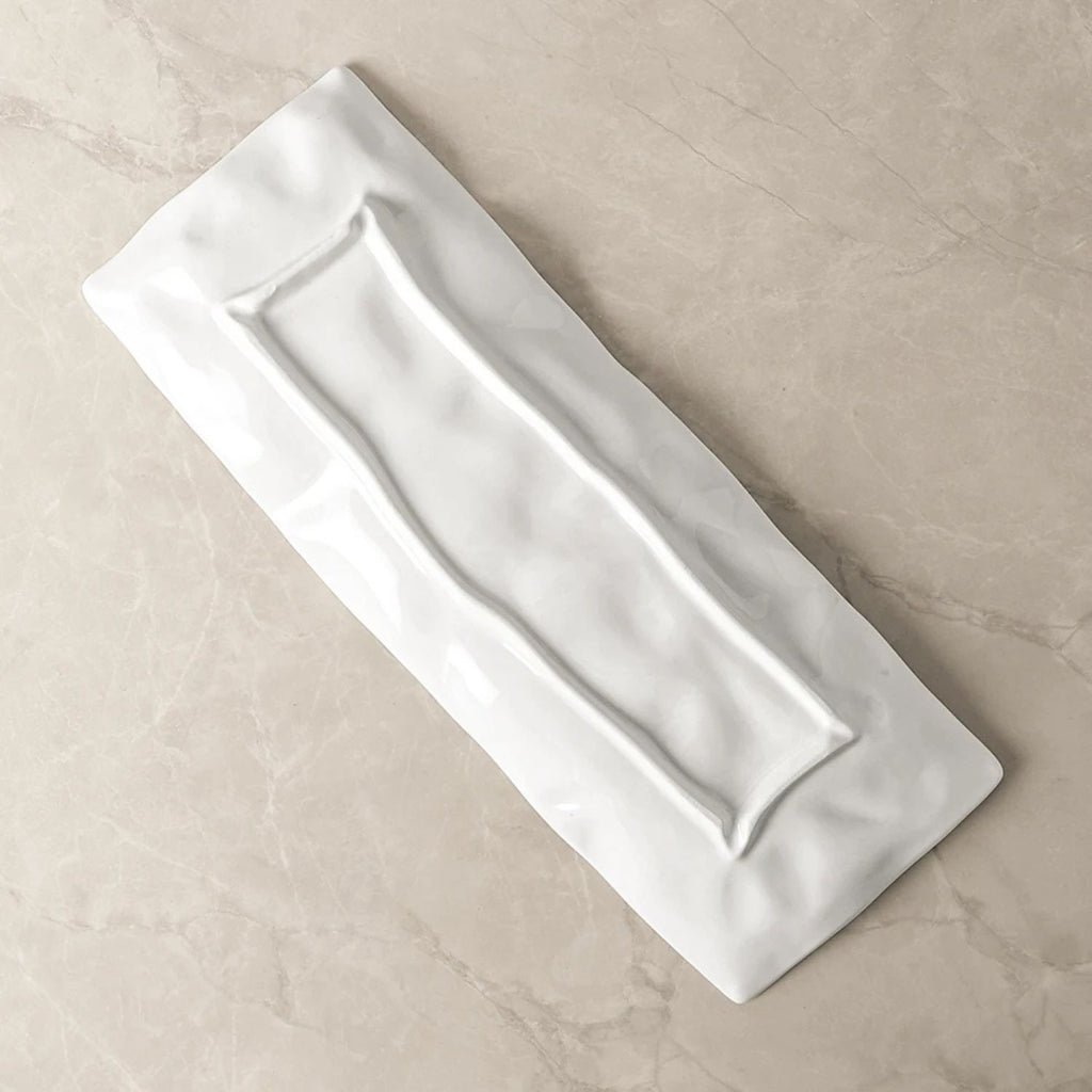 Rectangular white ceramic tray on a beige surface