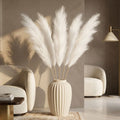 White pampas grass stems in ribbed cream floor vase in neutral living room