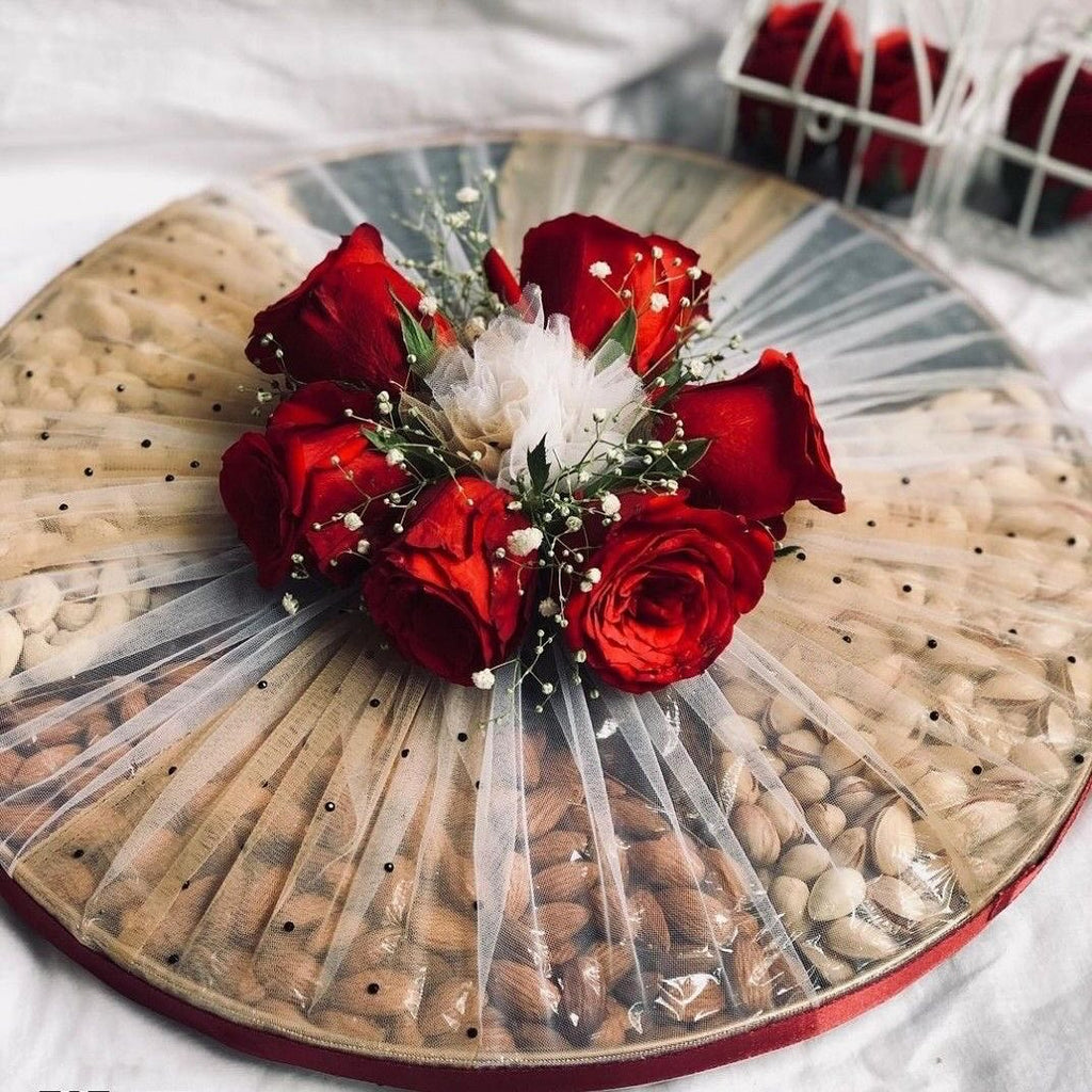 Close-up of red rose and tulle arrangement on dry fruit tray