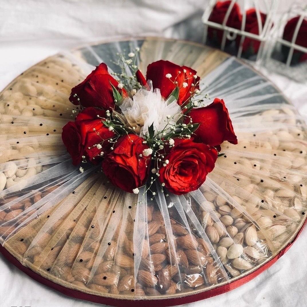 Close-up of red rose and tulle arrangement on dry fruit tray