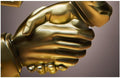 Gold holding hands heart sculpture - close-up detail of clasped hands with heart