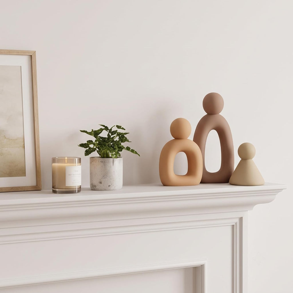 Abstract family sculpture set styled on white fireplace mantel
