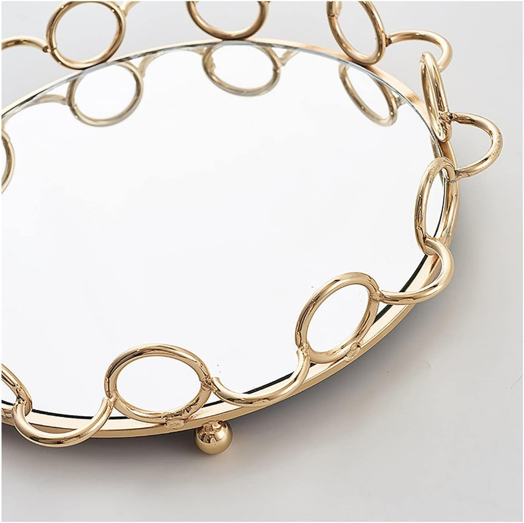 Gold ring chain mirror tray styled on marble surface with white flowers and books in background