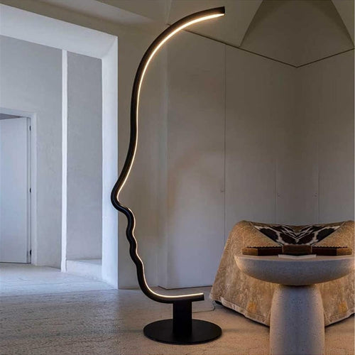 Abstract human face LED floor lamp glowing warm white in bedroom