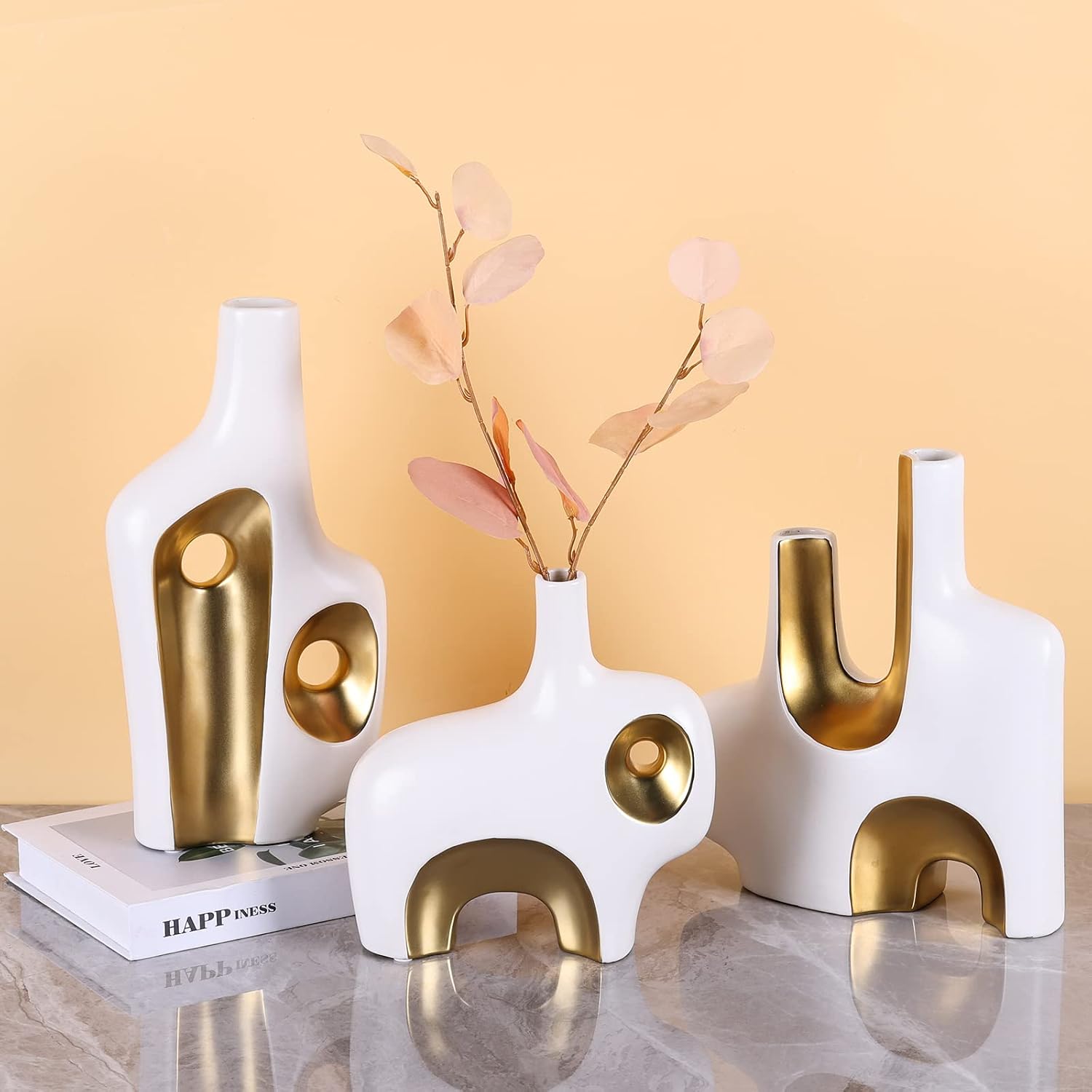 Abstract art vase set of 3 on marble surface with warm background
