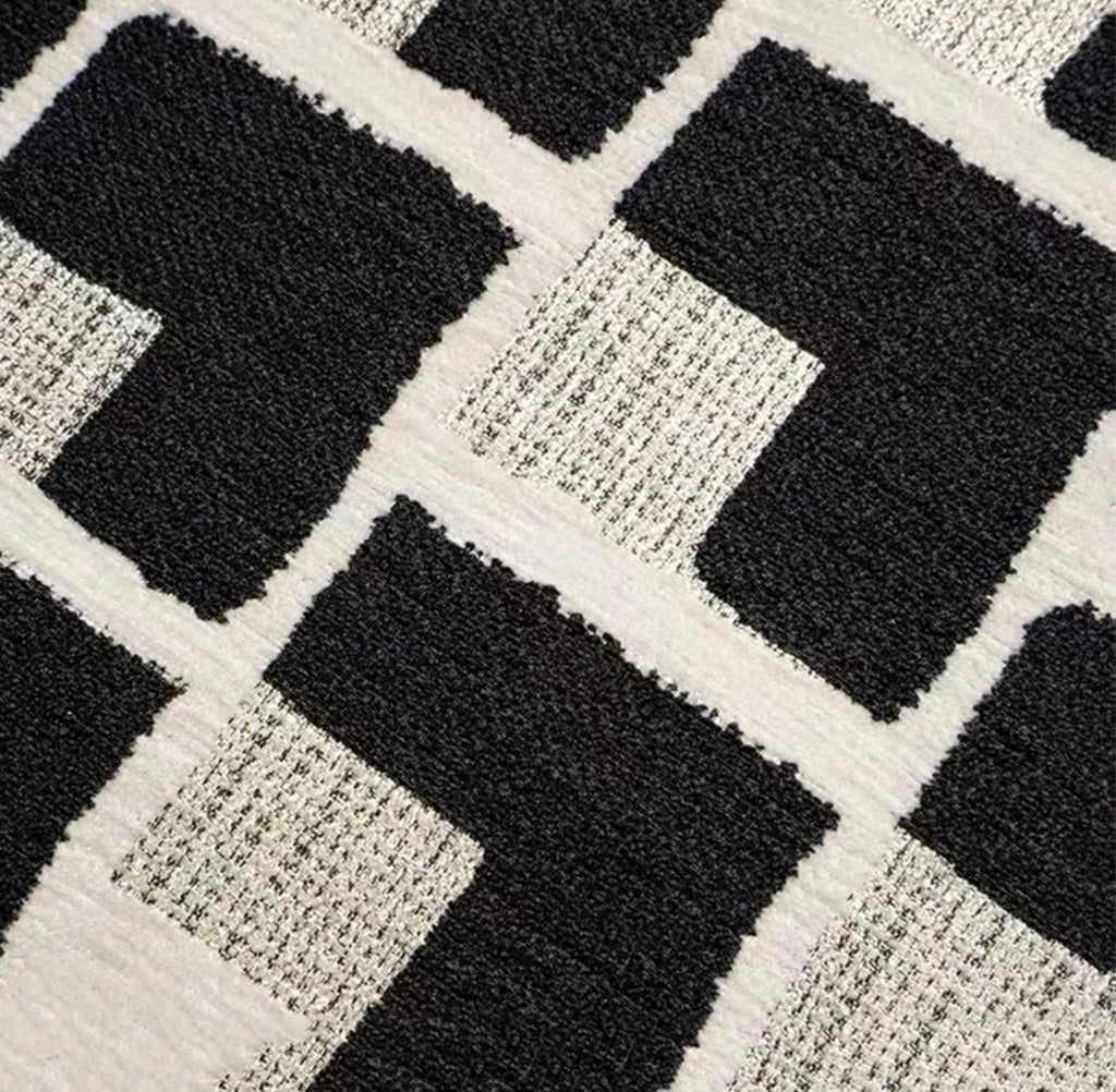 Close-up of the black border and edge of the black and cream geometric cushion