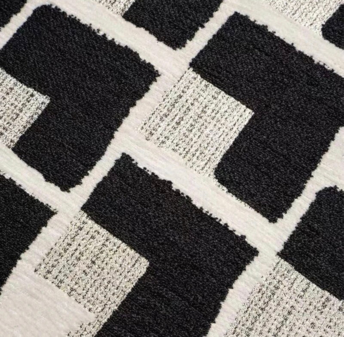 Close-up of the black border and edge of the black and cream geometric cushion