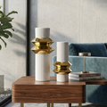 Ribbed white and gold vases styled in a modern living room setting