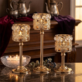 Gold crystal filigree candle holder set of 3 on marble table with candlelight in moody setting
