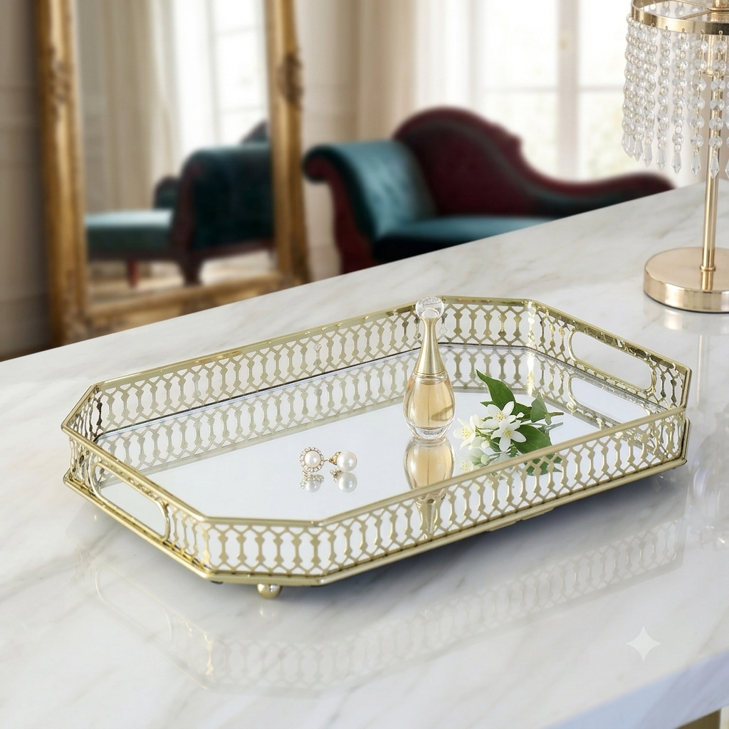 Gold filigree octagonal mirror tray styled on marble dressing table with perfume, pearl earrings and white flowers