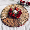 Round dry fruit tray with assorted nuts and red rose floral centrepiece