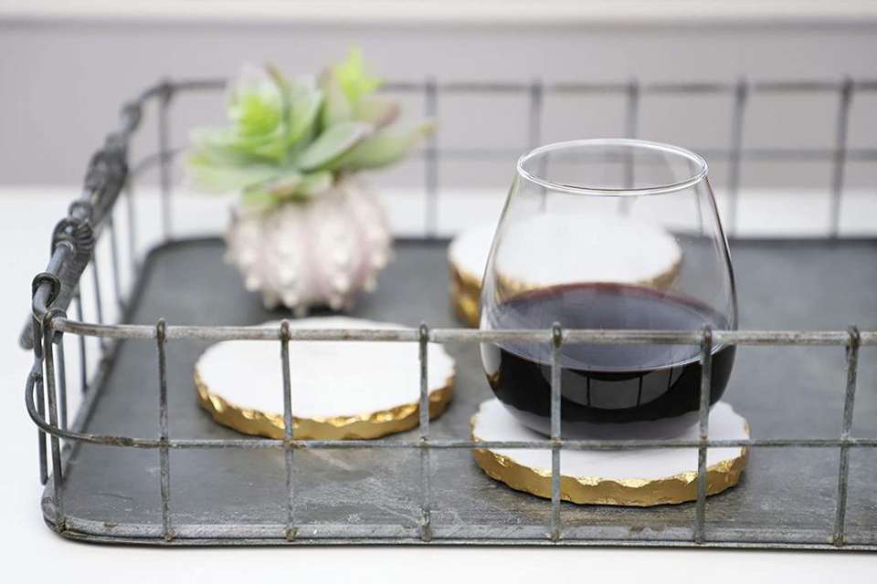 Set of four white marble coasters with textured gold edges