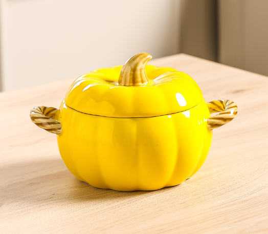 Yellow pumpkin-shaped ceramic casserole dish with matching lid and twisted side handles