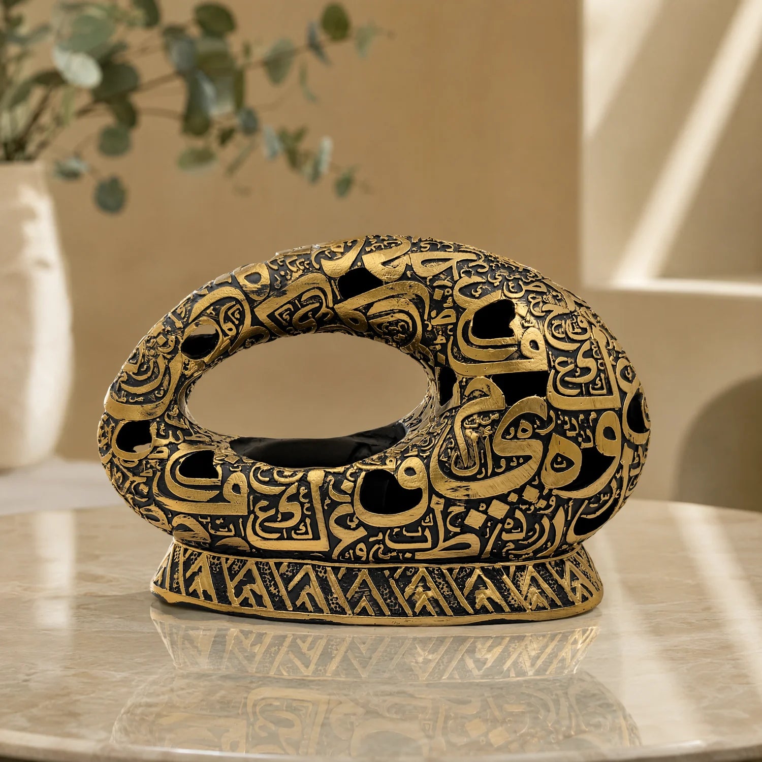 Arabic Calligraphy Oud Burner Black and Gold 12x18.5cm – styled on marble table in warm beige room with eucalyptus in background