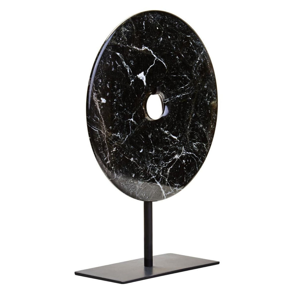 A black marble round wall plaque with a central hole, mounted on a black metal stand with a rectangular base, shown against a plain white background.