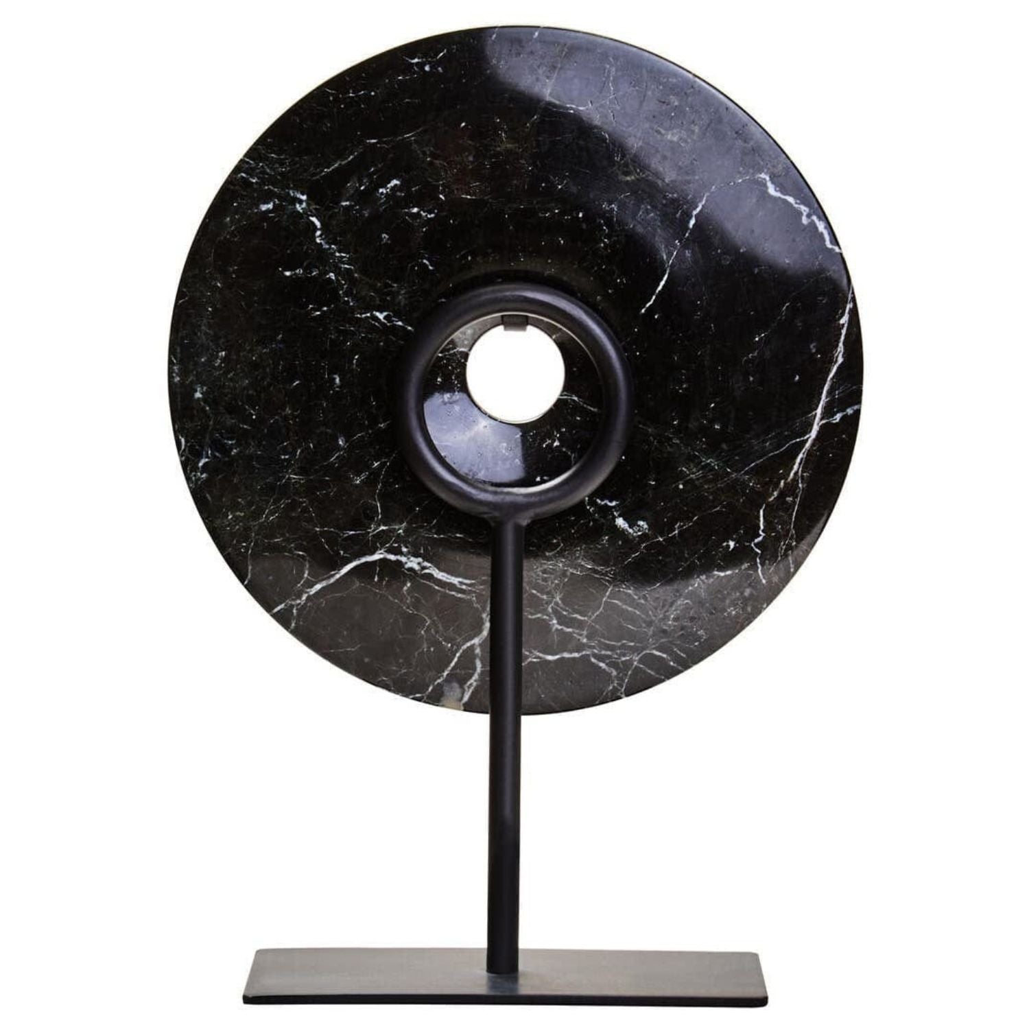 A modern black table lamp featuring a large circular black marble shade with white veining, supported by a slim black metal stand with a rectangular base.