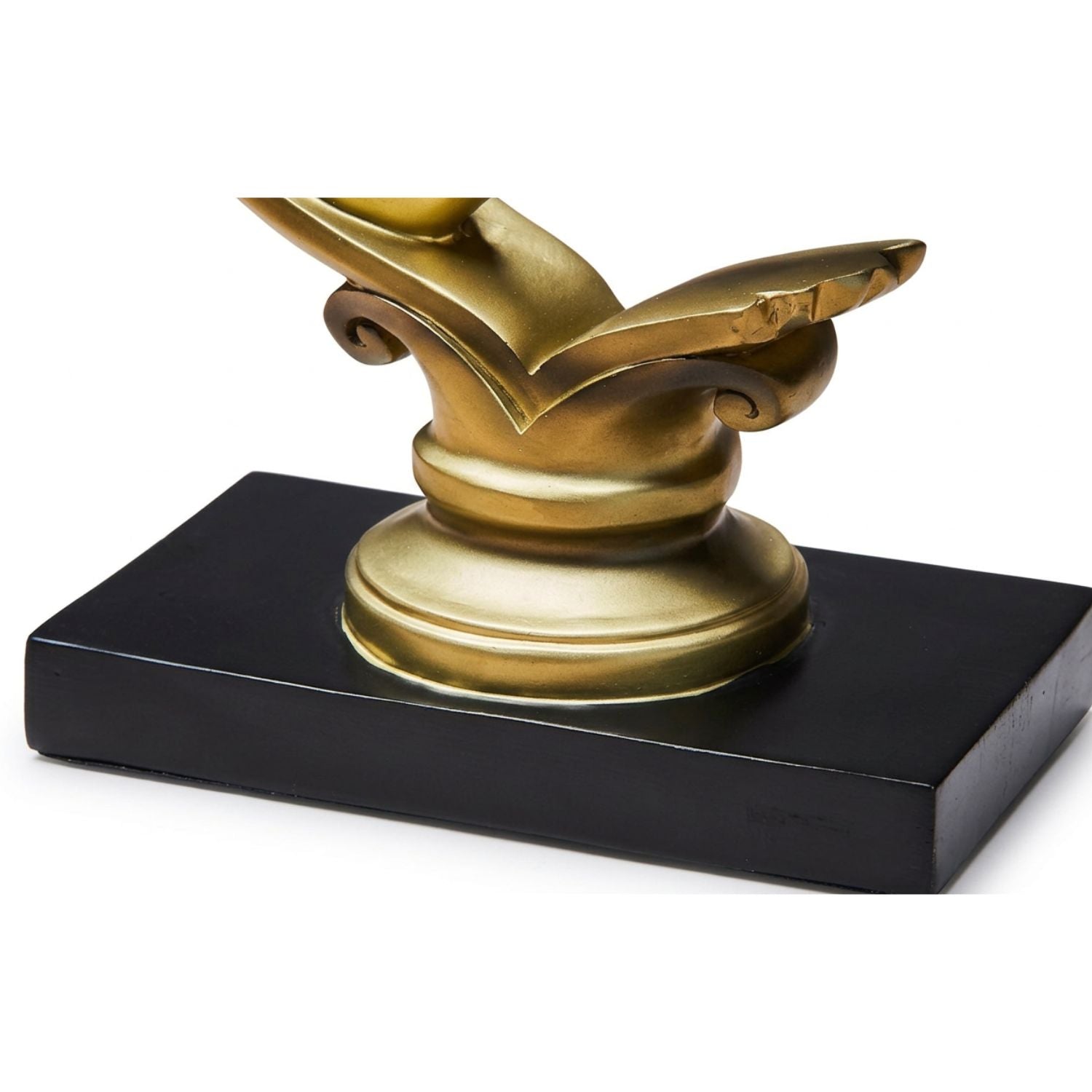 A decorative object featuring a polished gold-toned sculptural top mounted on a rectangular black base, photographed against a plain white background.