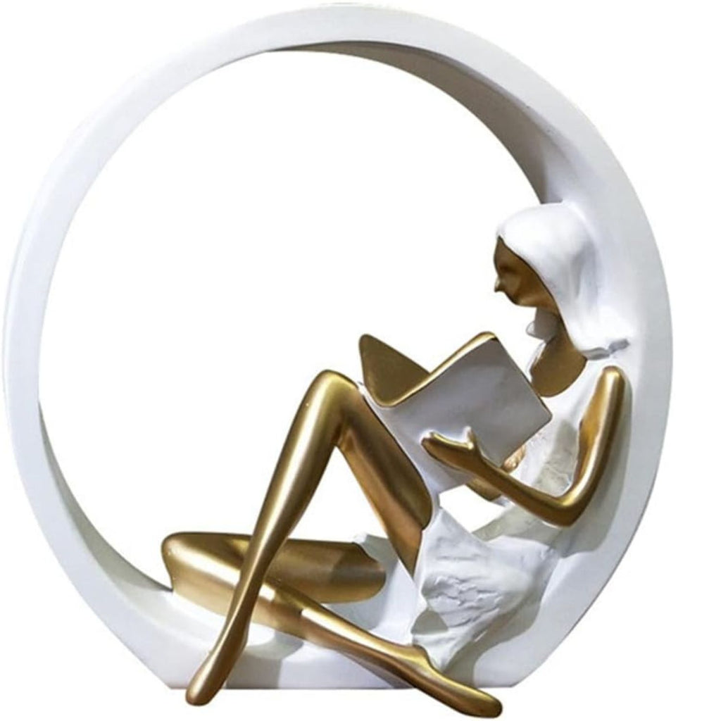 A decorative sculpture of a seated woman reading inside a large circular white frame, with a metallic gold figure and white dress against a plain white background.