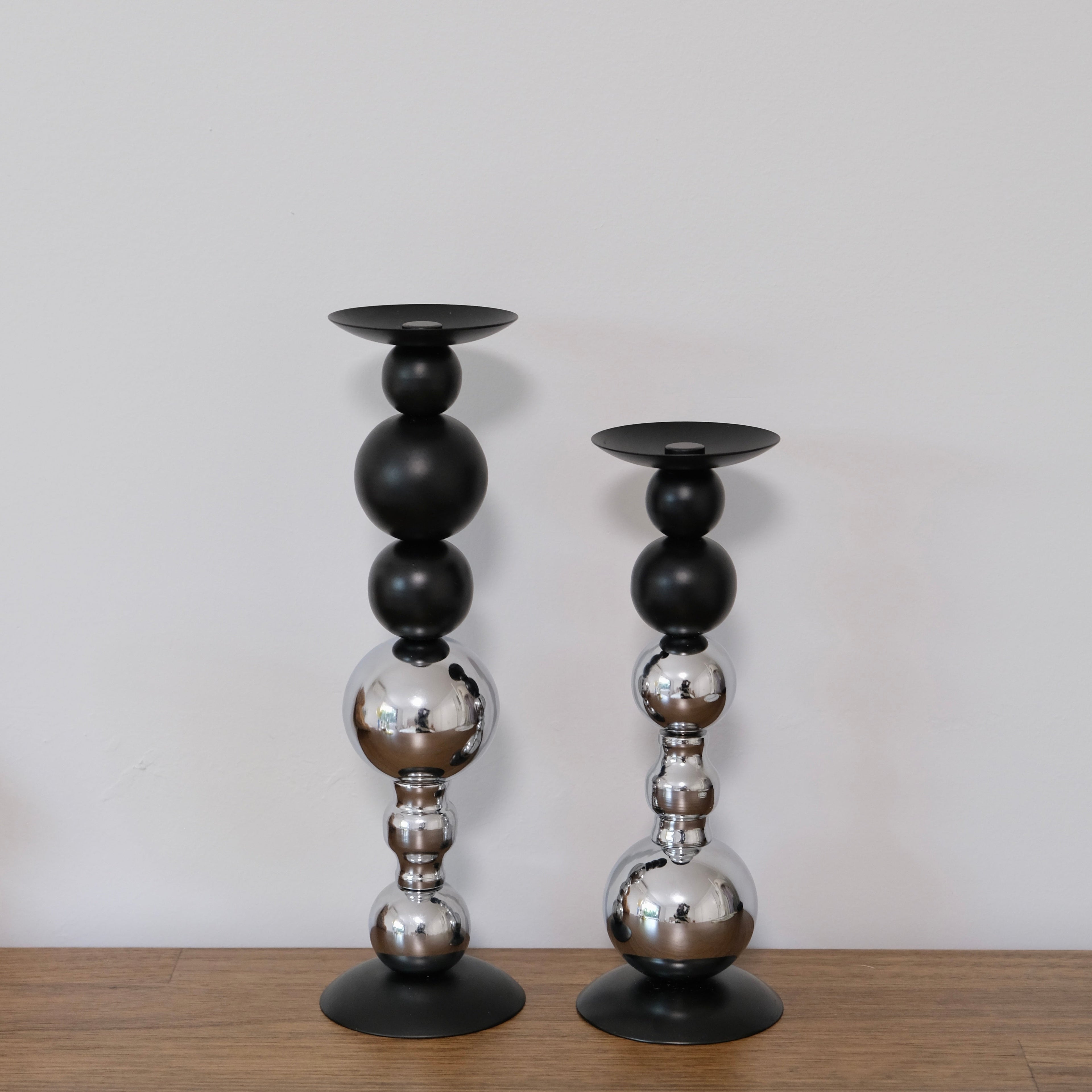 Pair of metallic ball stack candle holders in black and chrome – large and small sizes