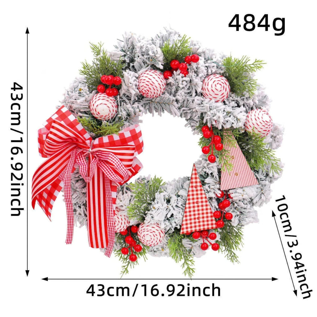 Frosted Christmas wreath with green pine branches, red berries, striped red-and-white ornaments, and a large red-and-white gingham bow, shown with dimension arrows and text indicating 43 cm width/height and 10 cm depth, plus '484g' in the top right.