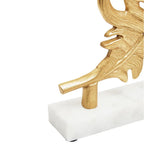 Close-up of marble base and gold stem of peacock feather sculpture