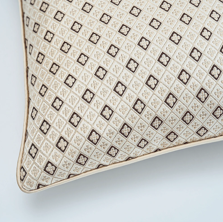 Side view of beige jacquard cushion showing piped edge and zip