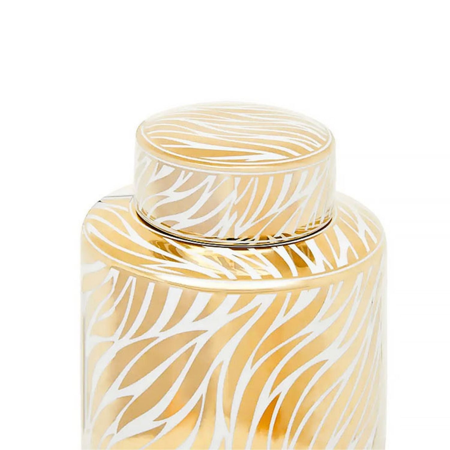 A close-up of a cylindrical glass jar with a matching lid, decorated with a white zebra-like pattern on a warm gold background, set against a plain white studio background.