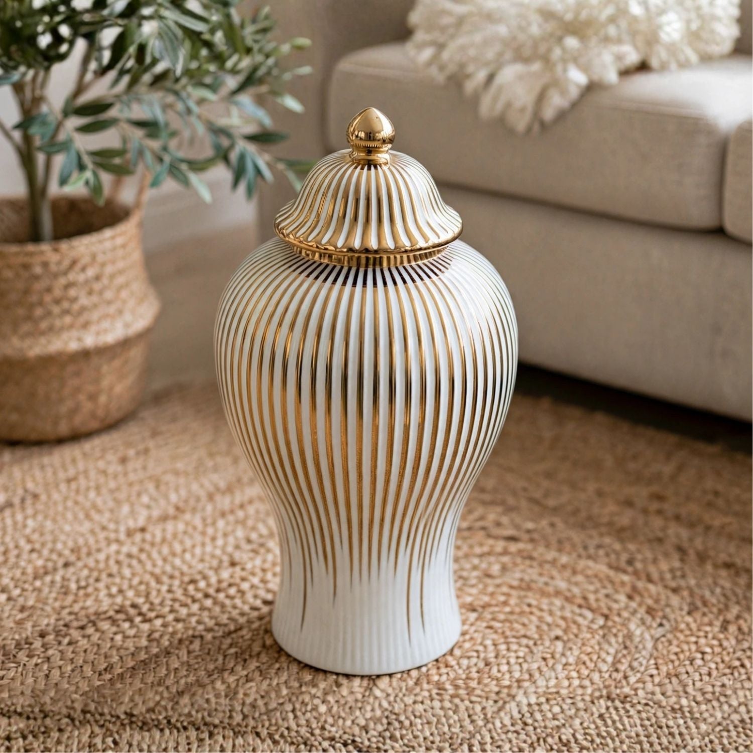 A ribbed ceramic lidded jar with a white body and gold vertical stripes, standing on a woven rug in a living room setting.
