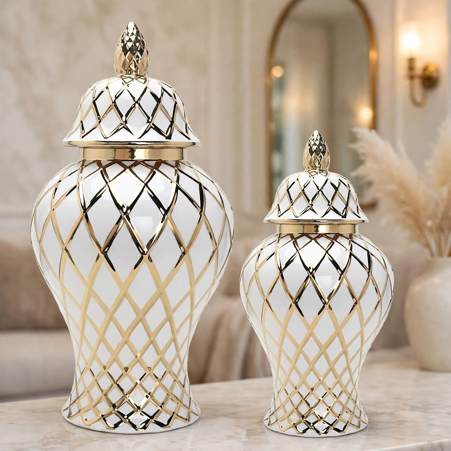 Two white ceramic lidded storage vases with gold and black diamond lattice patterns, displayed on a marble surface in a softly lit interior setting.