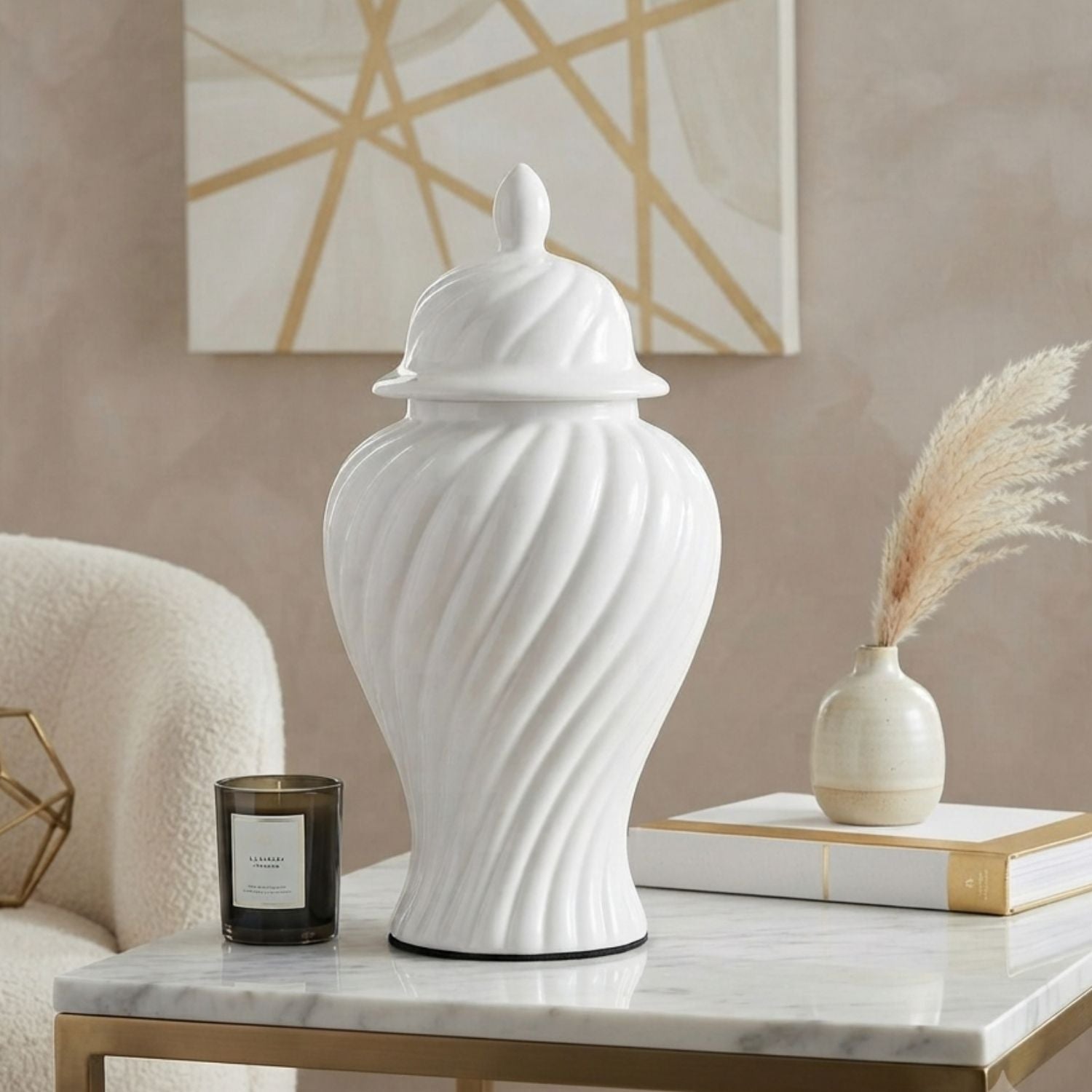 A white ceramic lidded jar with a ribbed spiral texture, displayed on a marble-topped side table in a styled room setting next to a candle, books, and a small vase.