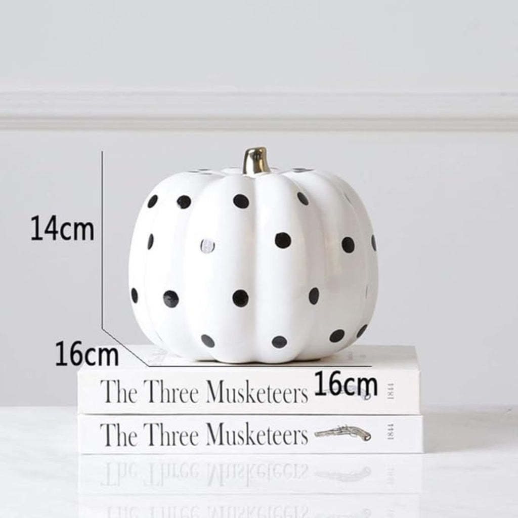 Large black and white harlequin pumpkin beside small white polka dot pumpkin