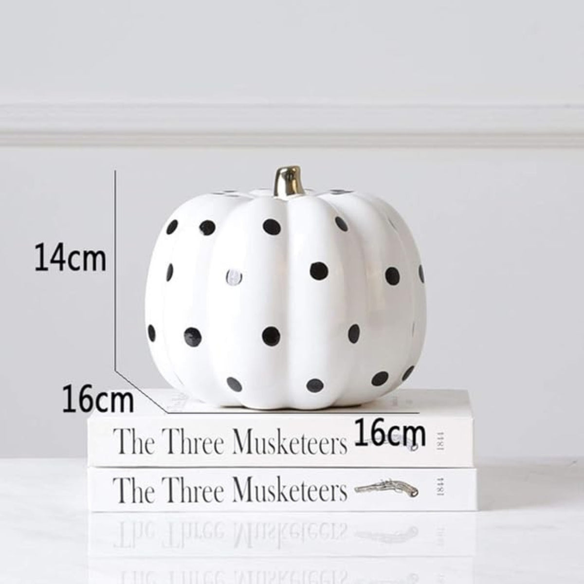 Large black and white harlequin pumpkin beside small white polka dot pumpkin