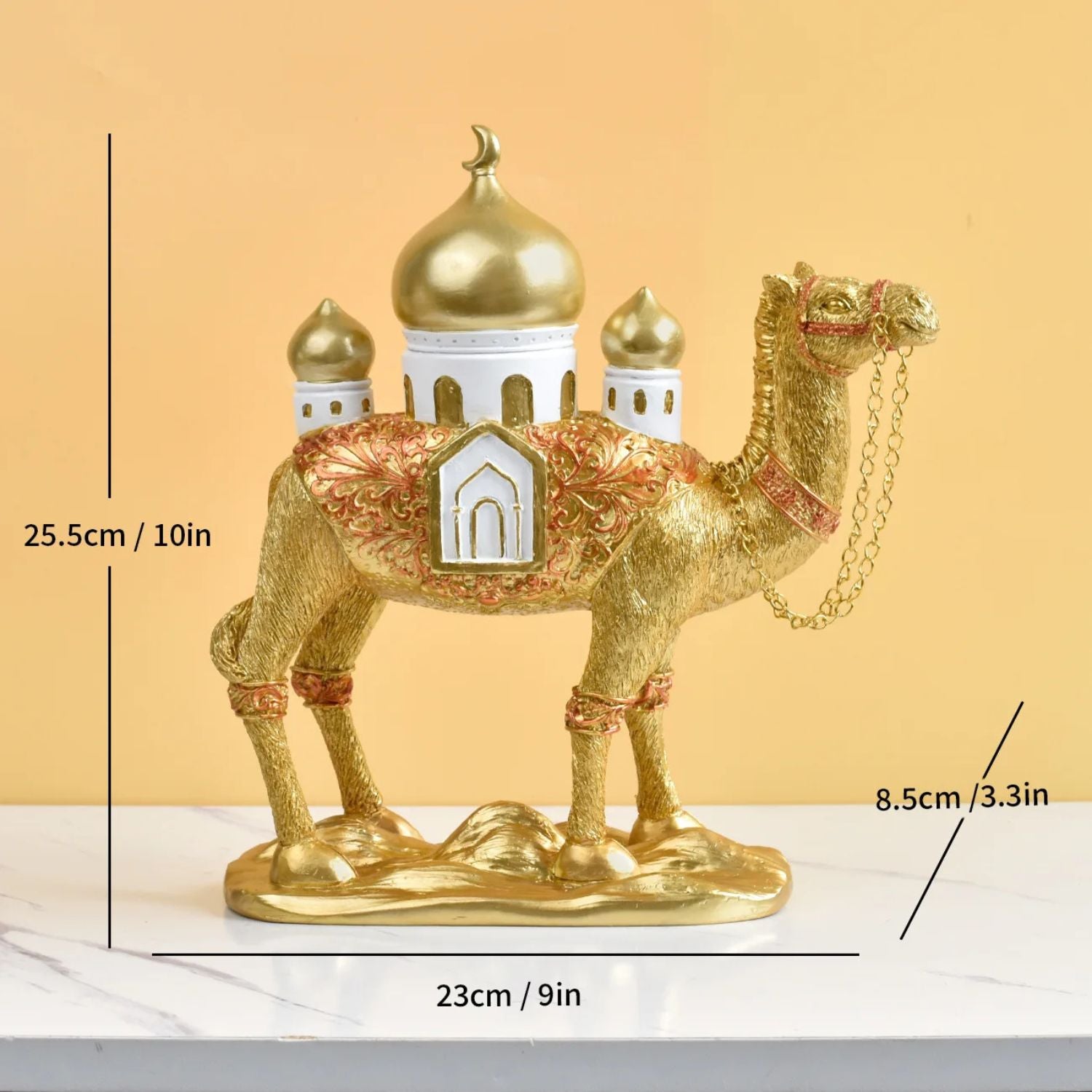 Decorative gold camel figurine with architectural elements on a beige background