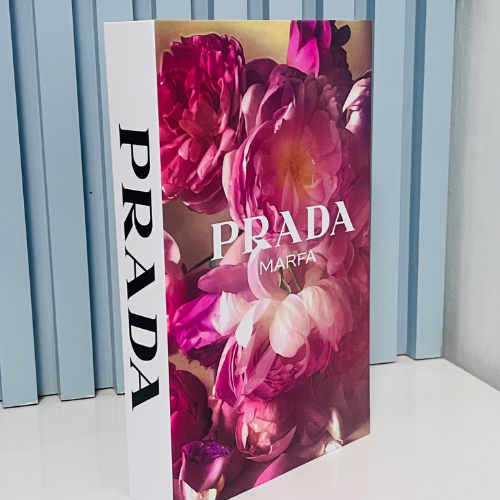 Prada Marfa decorative coffee table book pink floral cover standing vertically against blue background