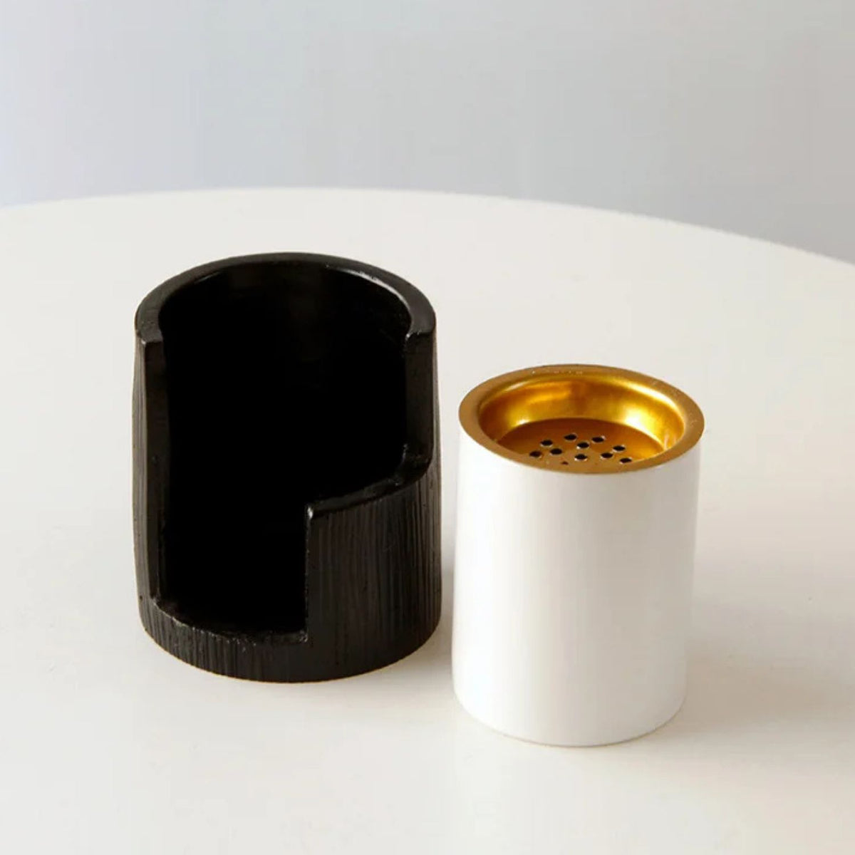 Black and white incense burner styled on a wooden table