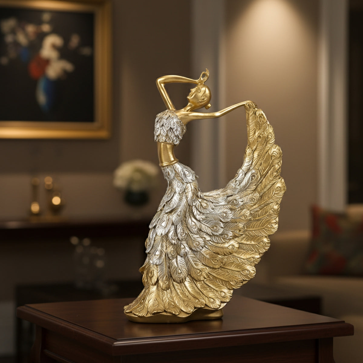 A decorative figurine of a dancing woman with a flowing feathered dress, finished in metallic gold and silver, displayed on a dark wooden table in a warmly lit living room setting.