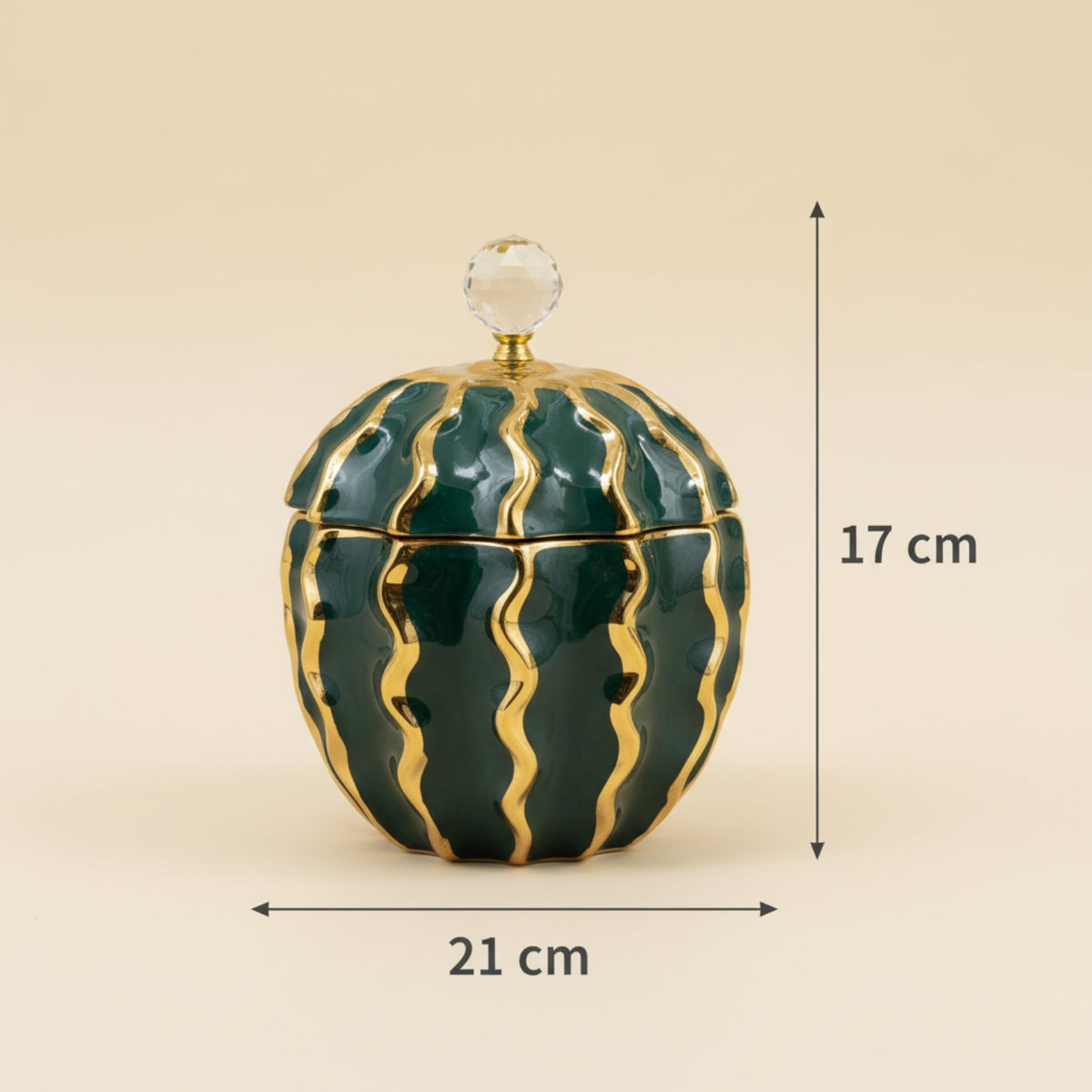 A small decorative lidded container with a rounded, cactus-like or watermelon-inspired pattern in glossy dark green and metallic gold, shown with dimension arrows and labels indicating 21 cm width and 17 cm height on a plain beige background.