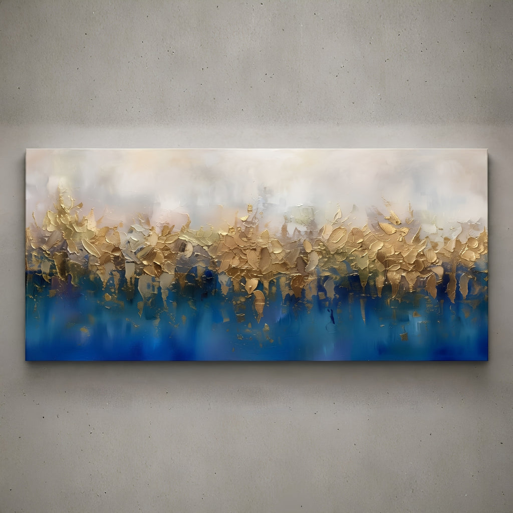 A wide rectangular abstract canvas painting mounted on a textured gray wall. The artwork features a soft cream and beige upper section blending into a deep blue lower section, with layered brushstrokes and reflective gold-like highlights across the center.