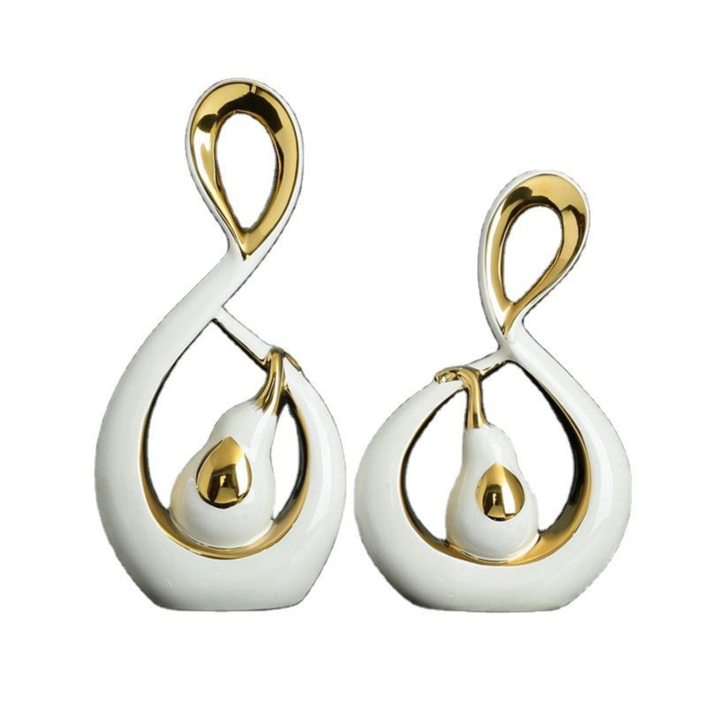 A pair of white and gold abstract teardrop-shaped earrings with a pear-like center detail, shown on a plain white background.
