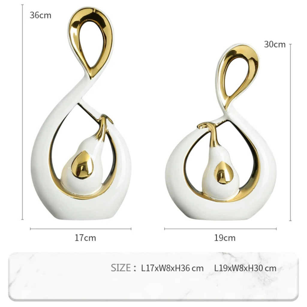 Two white and gold abstract teardrop-shaped decorative sculptures shown with dimension labels and measurements on a white background.