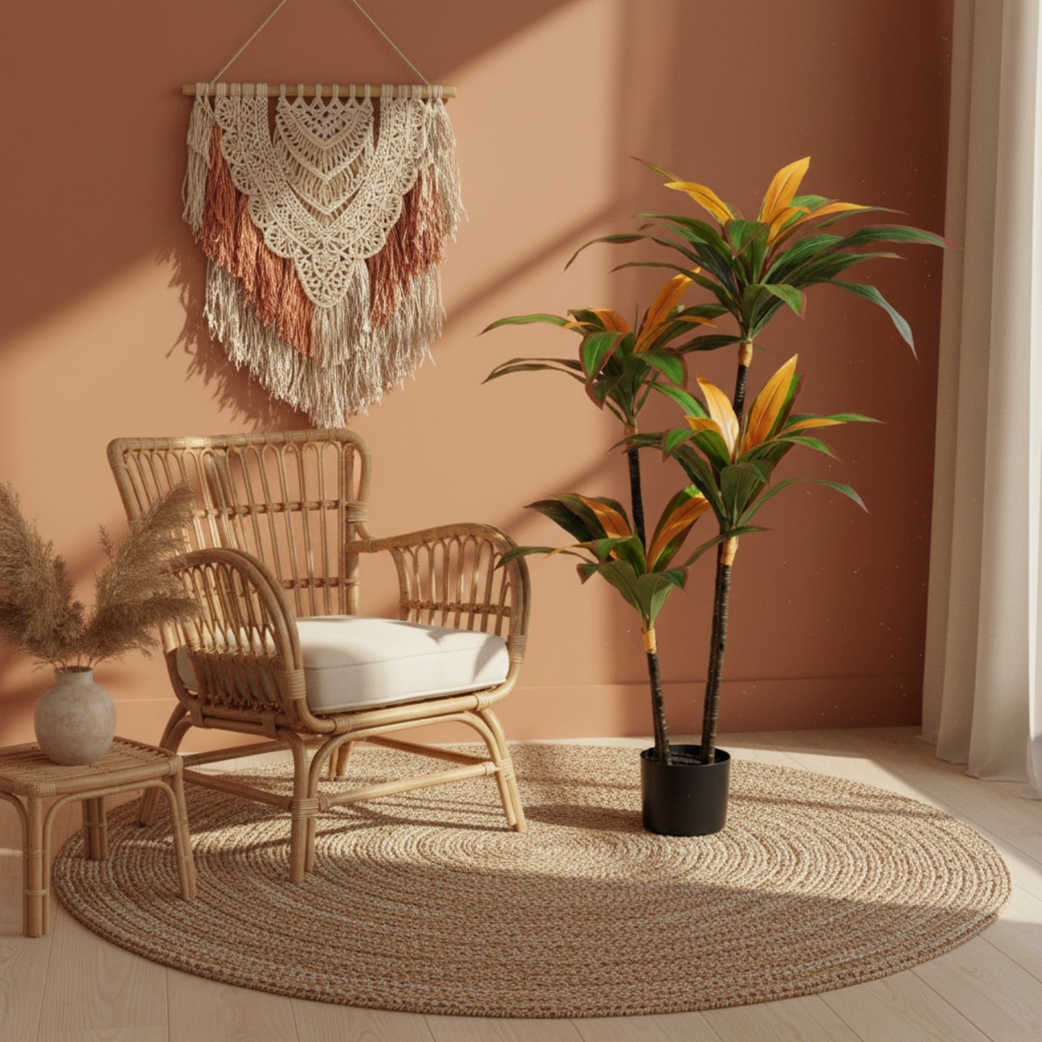 A styled boho room scene featuring a natural rattan armchair with a white cushion, a large round braided jute rug, a potted tropical plant, and a cream macrame wall hanging against a terracotta-colored wall.