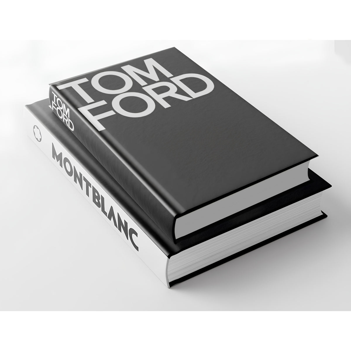 Two hardcover books stacked at an angle on a light gray background. The top book is black with large white 'TOM FORD' lettering on the cover, and the bottom book is white with 'TOM FORD' and 'MONTBLANC' printed on the spine.
