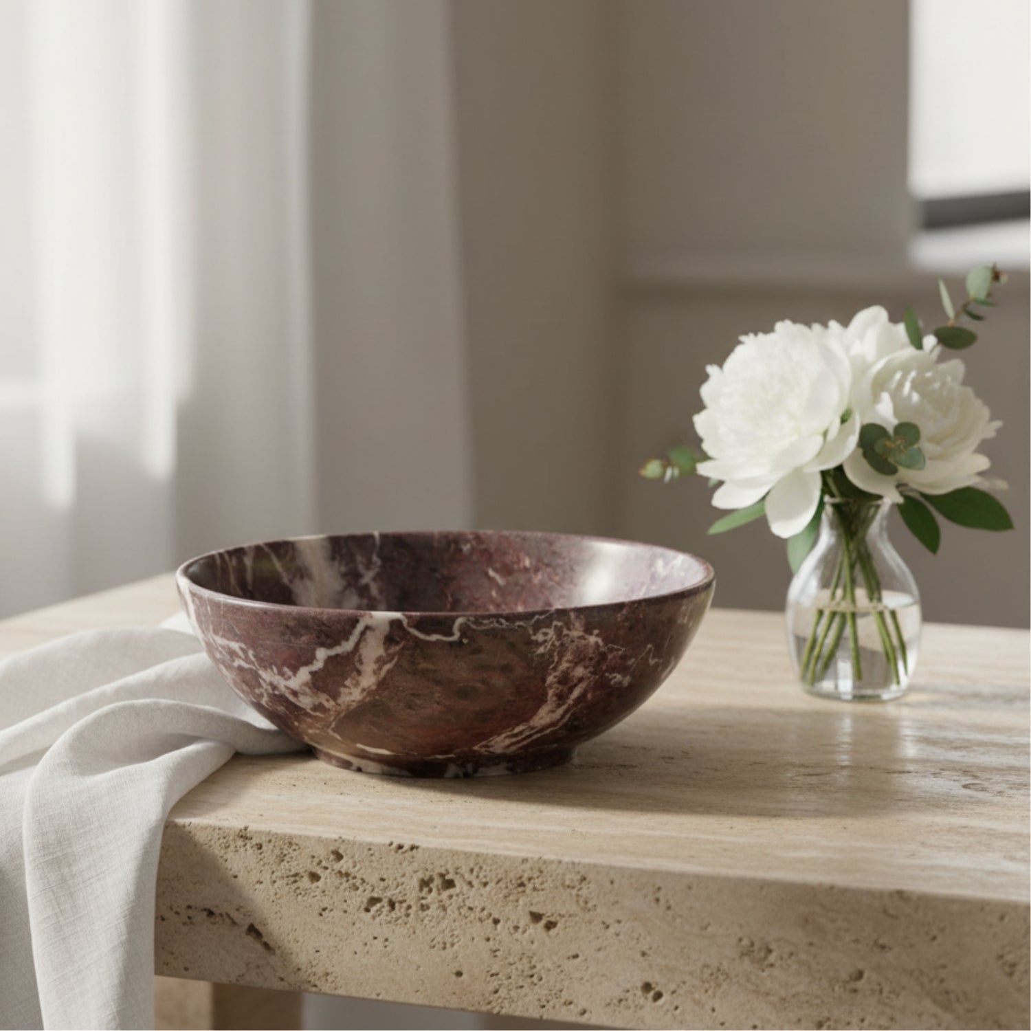 A handmade stone bowl with a reddish-brown and white marbled pattern, resting on a textured brown paper background.