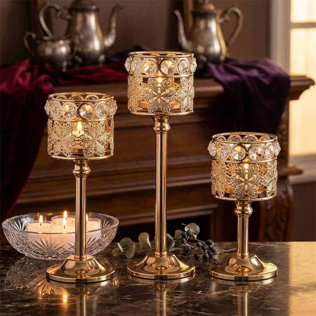 Three ornate gold candlestick holders with crystal accents are arranged on a dark marble table, with lit candles in a glass bowl and a warm, elegant interior background.